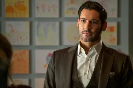 Bearded man in a dark suit and white shirt gazes forward before framed children's drawings; 2K Quad HD PC desktop wallpaper and background from a TV drama.