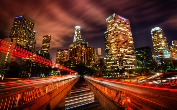 Time-lapse night view of Los Angeles city skyline with illuminated skyscrapers and light trails, captured in 4K Ultra HD for a vibrant desktop background.