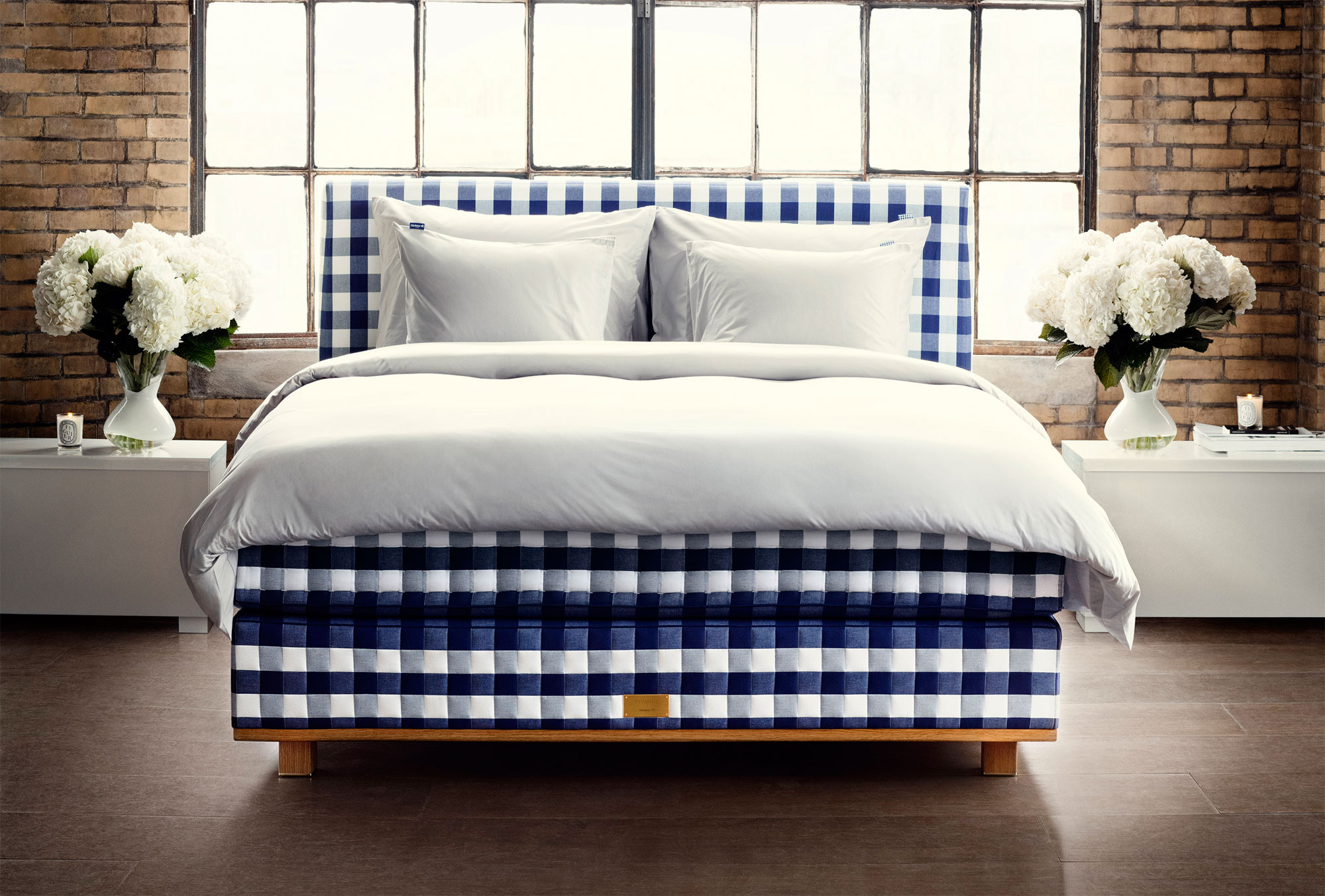 Cozy bedroom with a stylish blue and white checkered bed set against a brick wall, perfect as a HD desktop wallpaper or background.