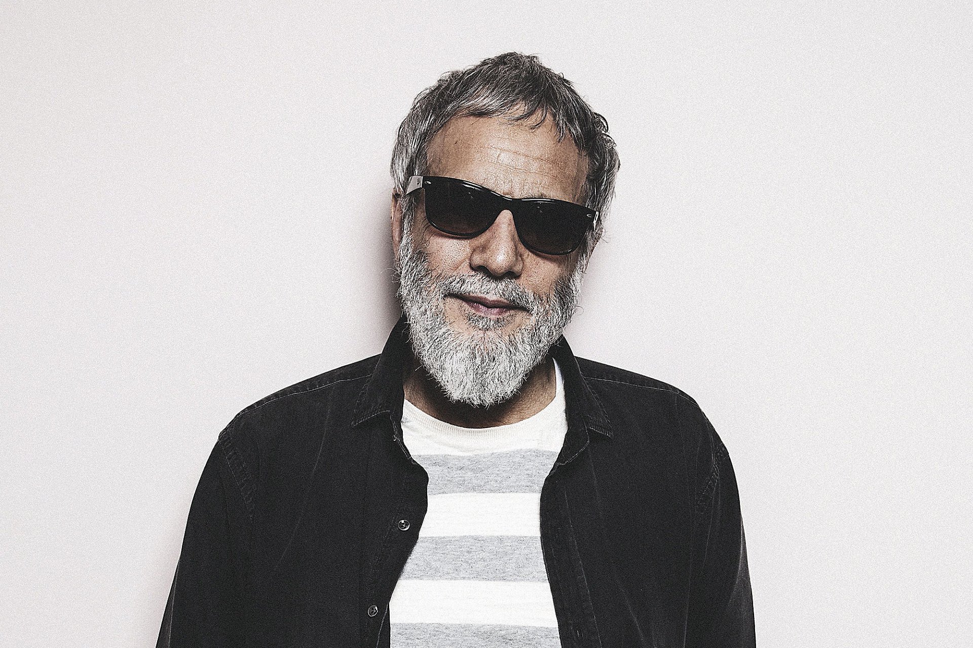 Stylish man with a beard and sunglasses posing for a HD desktop wallpaper background.