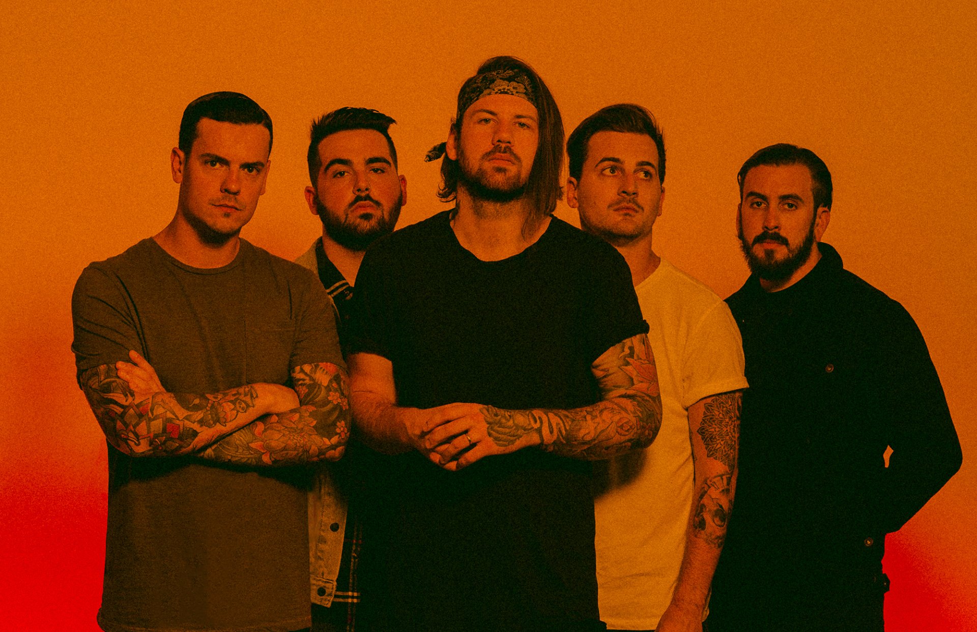 Beartooth band members posing together for an HD desktop wallpaper with an orange background.