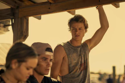 Rudy Pankow from the TV show Outer Banks pictured in a casual sleeveless shirt, featured in a HD PC desktop wallpaper and background.