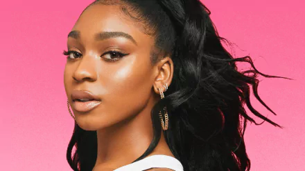 HD desktop wallpaper featuring a close-up portrait of a woman with striking makeup and a stylish ponytail set against a vibrant pink background.