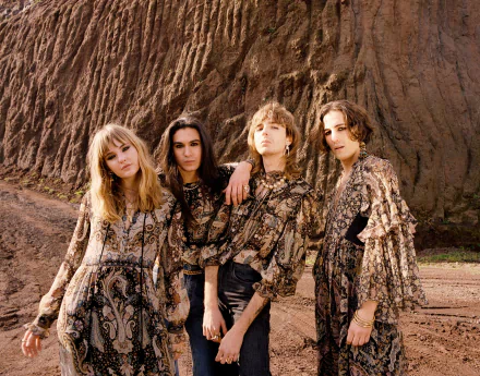 HD desktop wallpaper featuring the band Maneskin posing in coordinated outfits against an earthy backdrop.