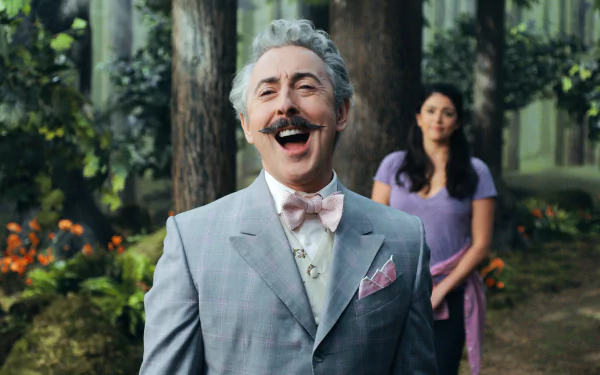 HD wallpaper featuring a cheerful man in a grey suit with a bow tie and a woman in purple standing in a forest from Schmigadoon!