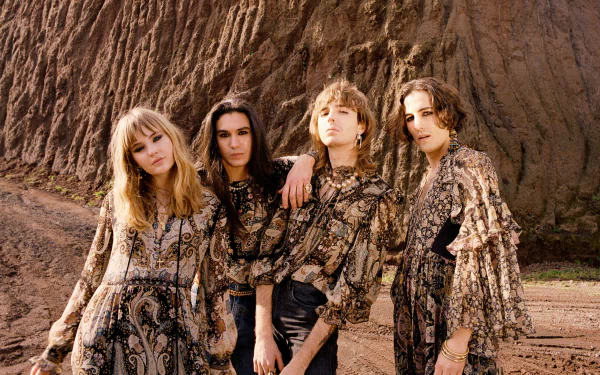 HD desktop wallpaper featuring the band Maneskin posing in coordinated outfits against an earthy backdrop.