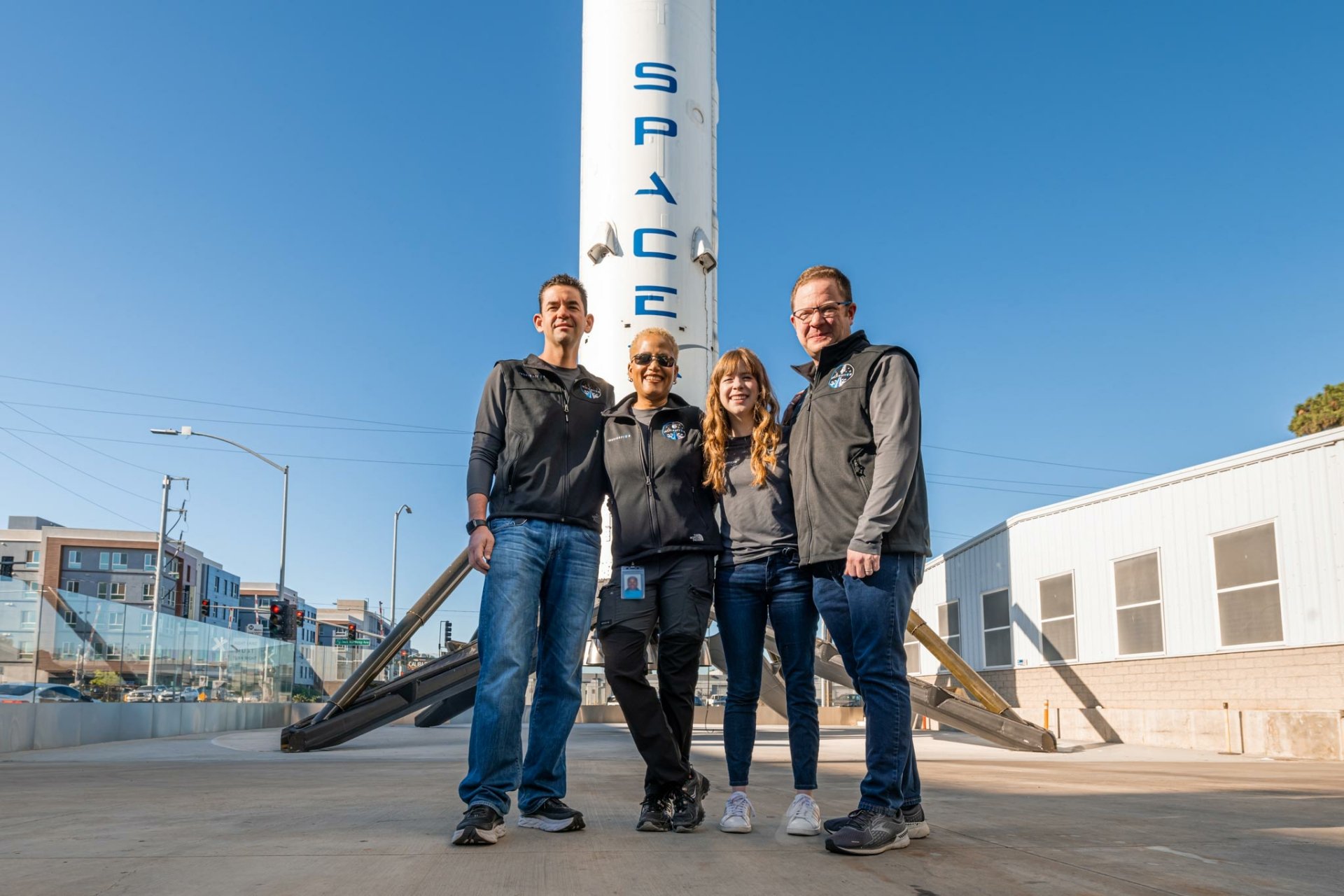 Inspiration4 mission crew posing in front of the SpaceX logo, providing motivation in this high-definition desktop wallpaper.