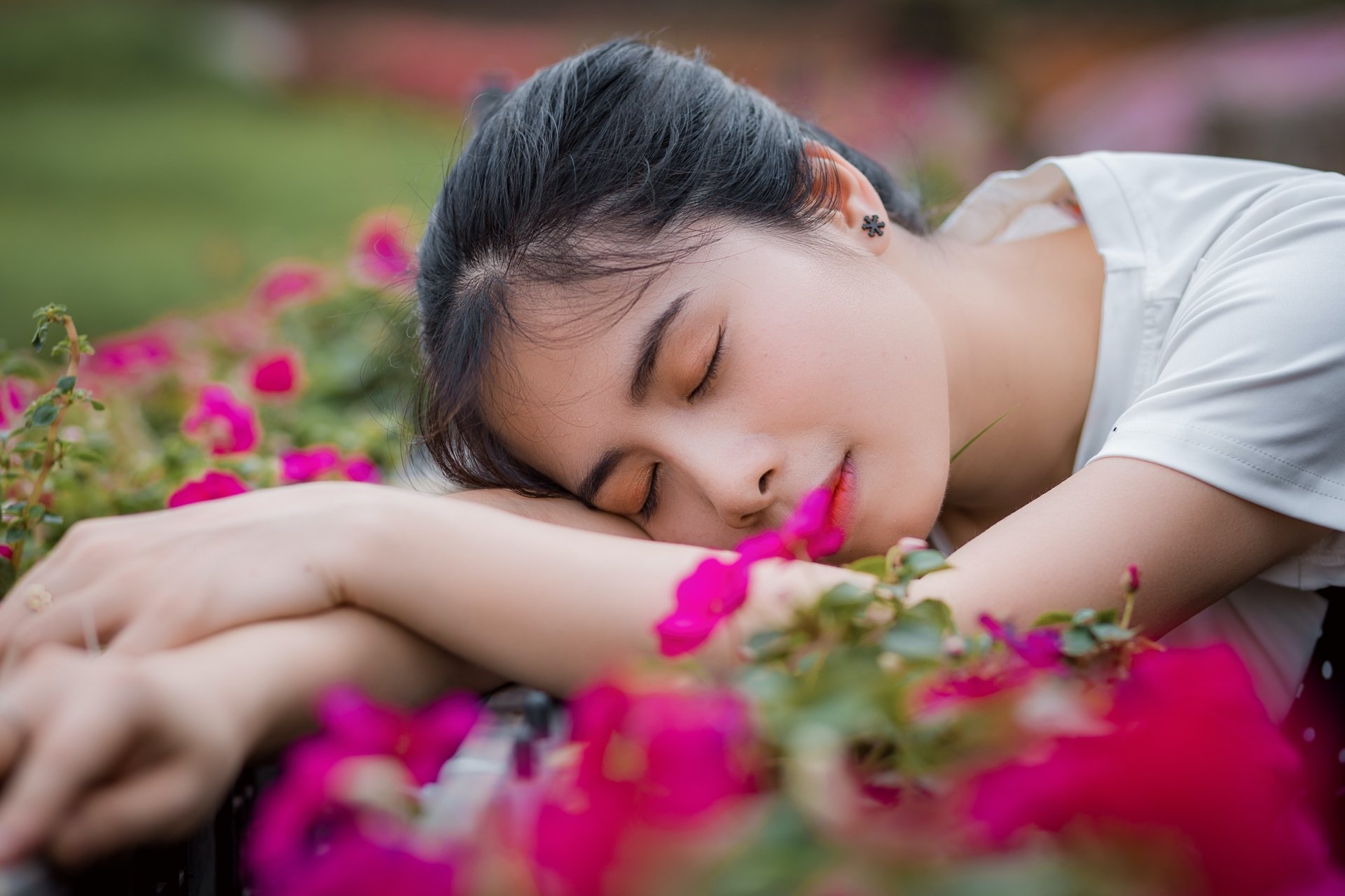 A peaceful Asian woman sleeping among vibrant pink flowers in a serene outdoor setting, captured in 4K Ultra HD for a stunning PC desktop wallpaper.