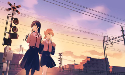 HD anime desktop wallpaper featuring Touko Nanami and Yuu Koito from Bloom into You standing near a railway crossing at sunset.
