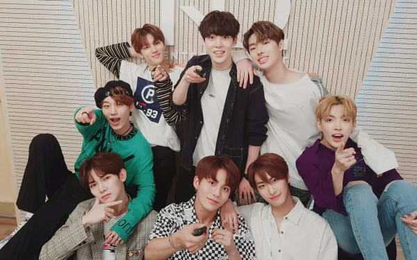 A vibrant HD desktop wallpaper featuring the members of ATEEZ posing together in a playful and energetic manner, showcasing their unity and passion for music.