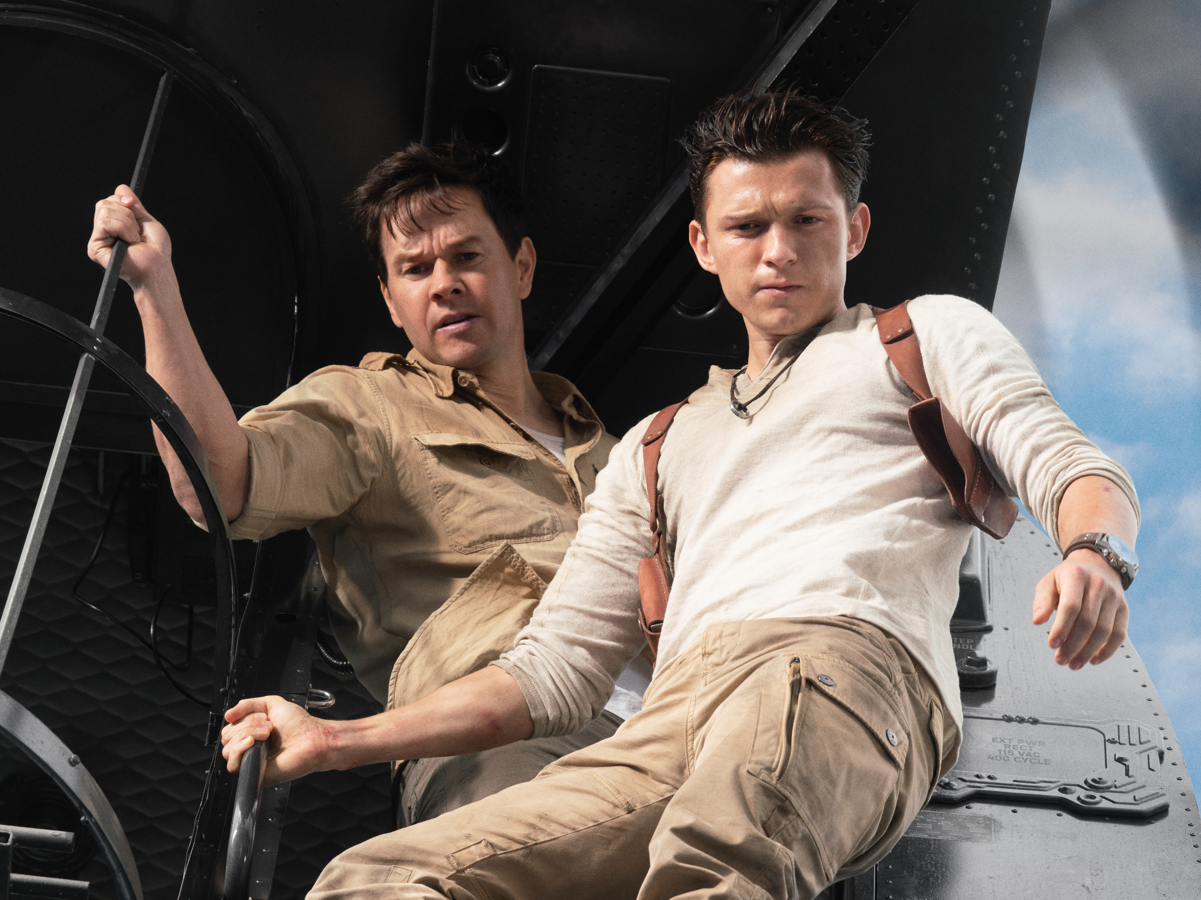 Promotional wallpaper featuring actors Mark Wahlberg and Tom Holland as characters Victor Sullivan and Nathan Drake from the movie Uncharted.