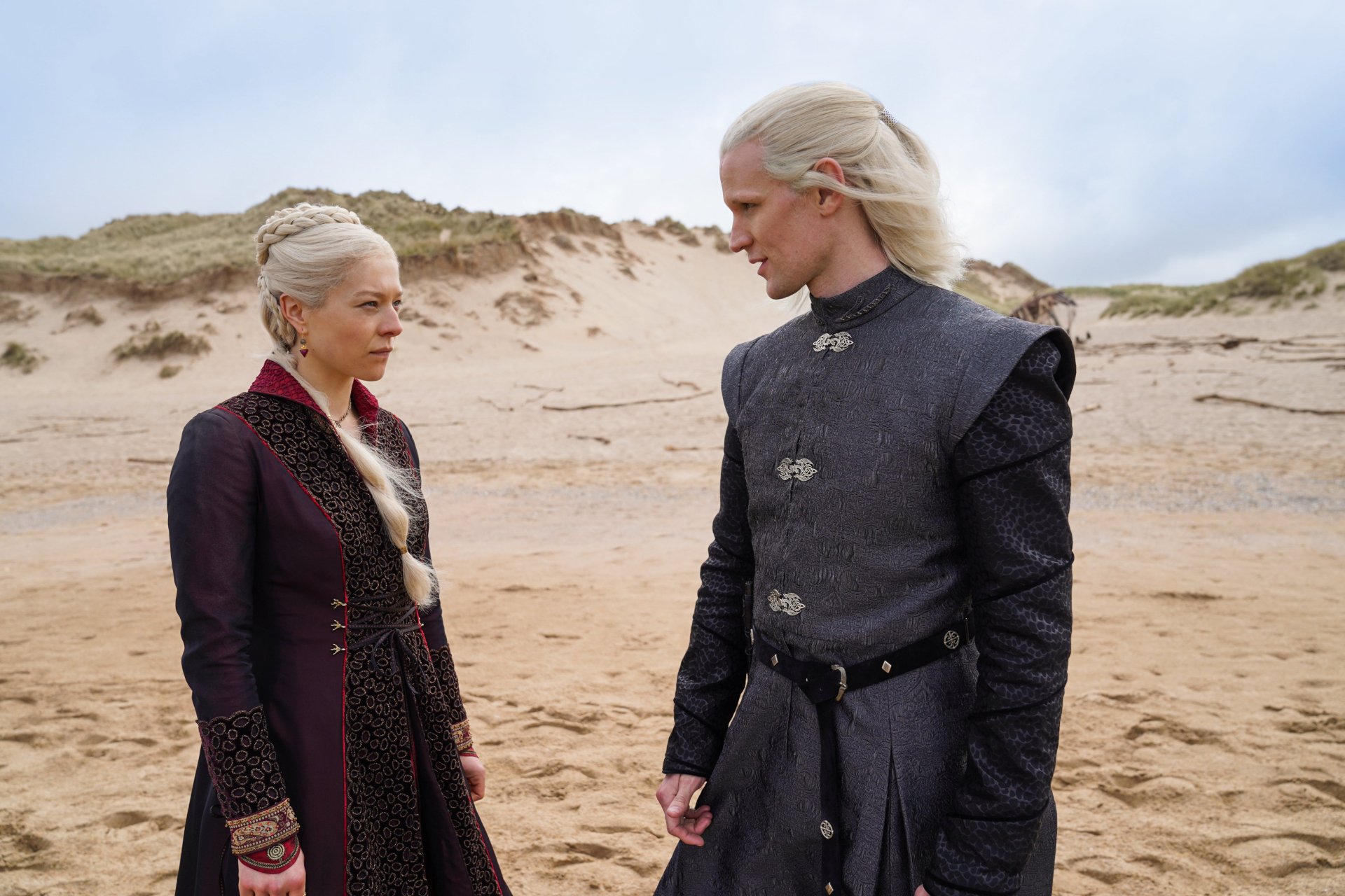 Emma D'Arcy as Rhaenyra Targaryen and Matt Smith as Daemon Targaryen in a 4K Ultra HD House of the Dragon TV show wallpaper on a sandy beach background.