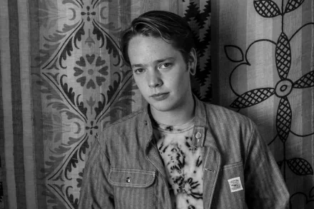 Black and white HD desktop wallpaper of a person against a patterned backdrop, evoking a contemplative mood.