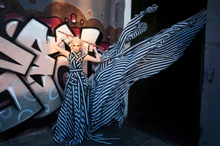Person in a dramatic black-and-white striped gown posed before graffiti, flowing fabric creating motion — bold music-themed 4K Ultra HD PC desktop wallpaper and background.