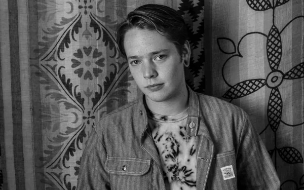 Black and white HD desktop wallpaper of a person against a patterned backdrop, evoking a contemplative mood.