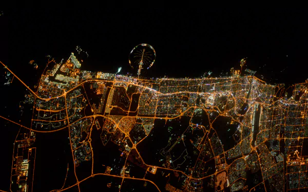 Aerial nighttime view of Dubai city lights from space, showcasing the man-made urban layout in stunning 4K Ultra HD detail.