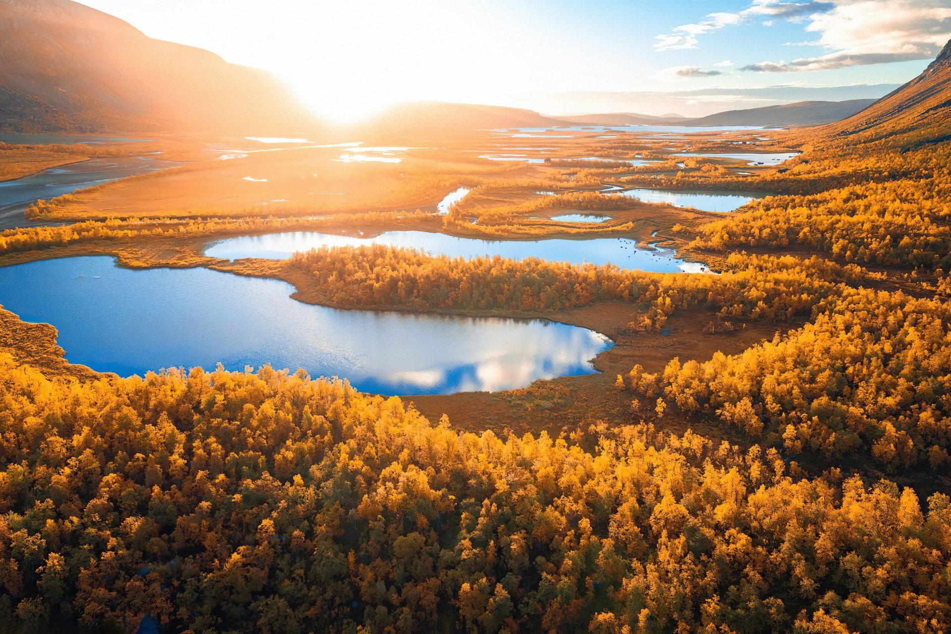 A stunning 4K Ultra HD landscape of a Swedish lake surrounded by vibrant fall foliage under a bright sky, showcasing the beauty of nature in autumn.