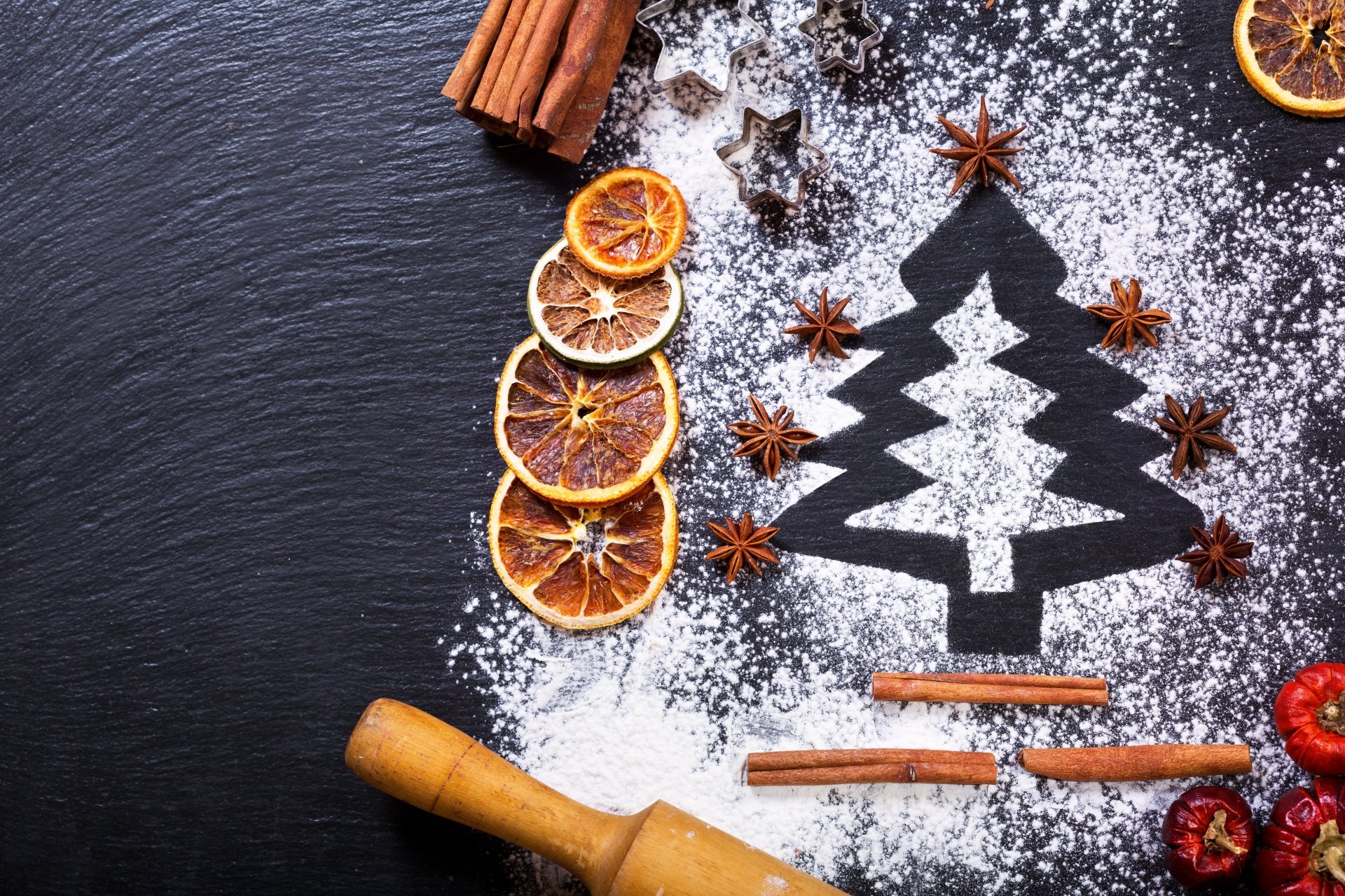 4K Ultra HD PC desktop wallpaper — still-life photography: Christmas tree silhouette dusted with powdered sugar on dark slate, framed by dried orange slices, cinnamon sticks and star anise.