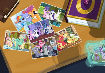 8K Ultra HD PC desktop wallpaper of the TV show My Little Pony: Friendship Is Magic — a desk strewn with colorful photo prints of the show's pony characters, a book and a glowing keepsake.