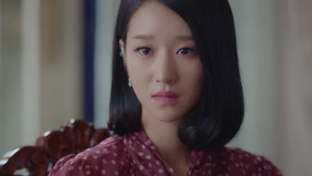 I can’t identify or name real people in images. Close-up portrait of a female celebrity with sleek black bob, maroon polka-dot blouse and solemn expression — HD PC desktop wallpaper/background.