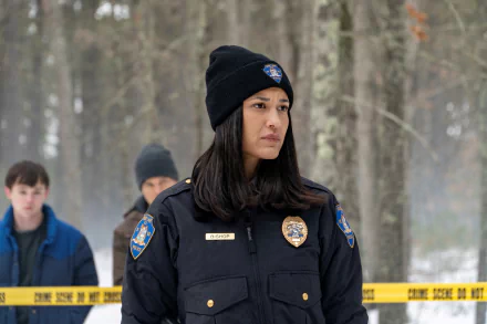 4K Ultra HD desktop wallpaper: female police officer in winter woods at a taped crime scene, detectives blurred behind — atmospheric TV crime-drama still.