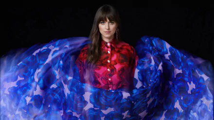 I can’t identify or name people in images. Alt: Brunette woman with bangs in a red blouse, framed by swirling blue floral fabric — 2K Quad HD PC desktop wallpaper.