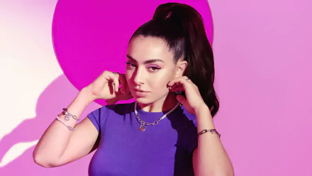 Portrait of a female music artist in a purple top with a high ponytail against a vibrant pink backdrop — 5K Ultra HD PC desktop wallpaper and background.