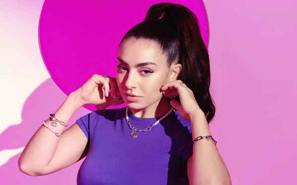 Portrait of a female music artist in a purple top with a high ponytail against a vibrant pink backdrop — 5K Ultra HD PC desktop wallpaper and background.