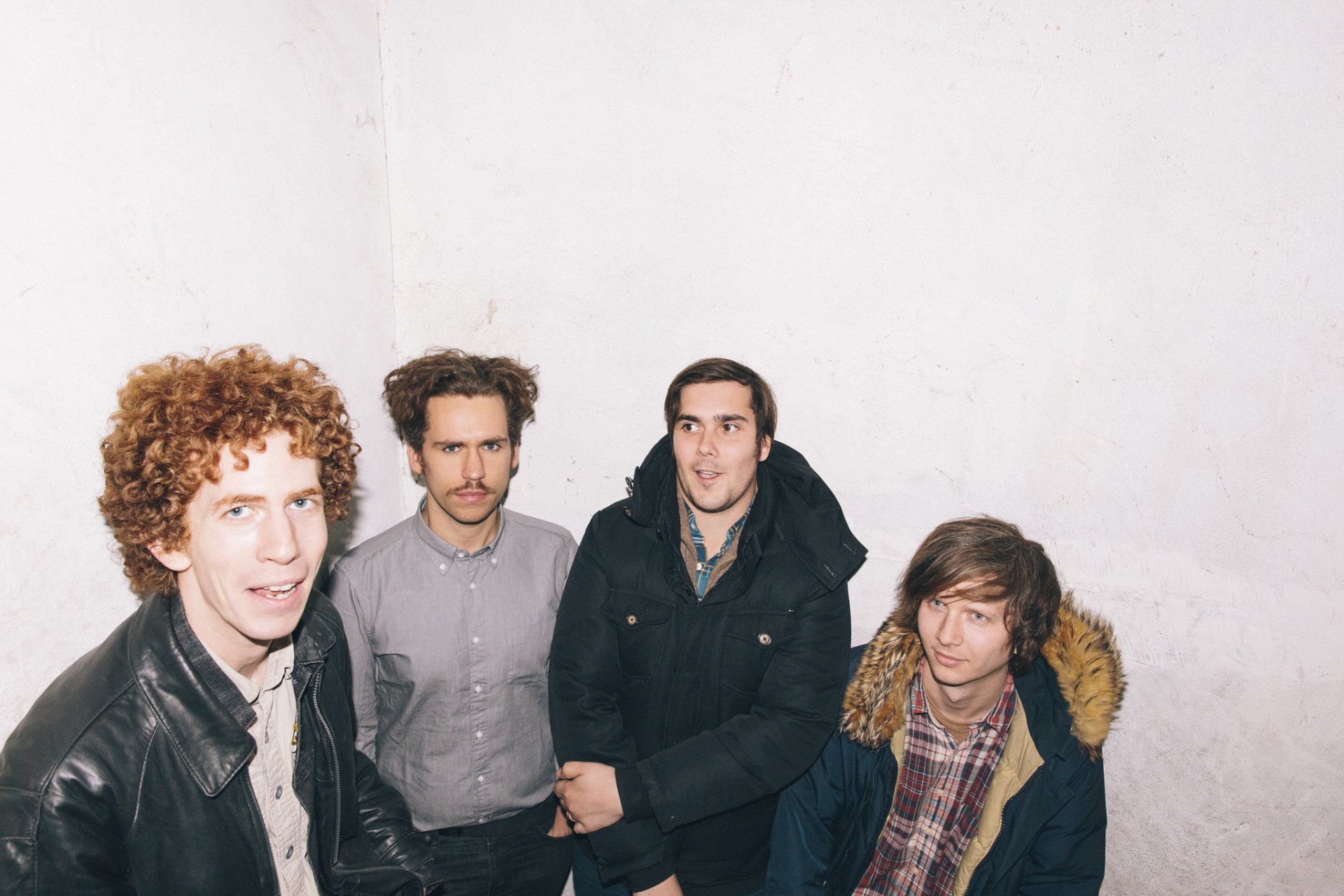 HD desktop wallpaper featuring Parquet Courts, with the band members standing against a white backdrop.