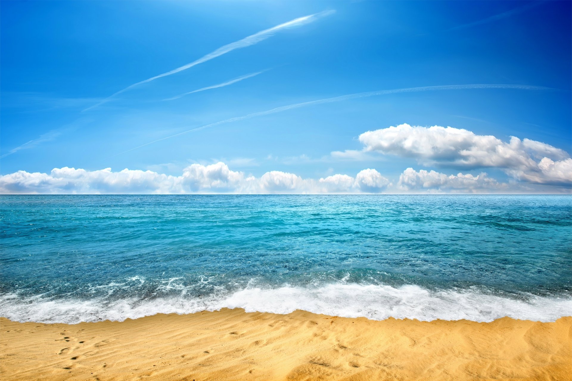 4K Ultra HD PC desktop wallpaper of a nature scene: ocean horizon with turquoise waves on a sandy beach under a blue sky, clouds and contrails.