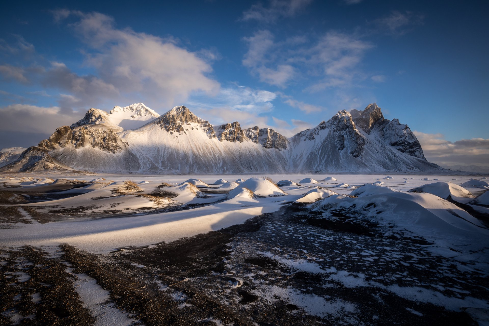 Snow-covered Vestrahorn Mountain in Iceland under a partly cloudy sky, captured in stunning 4K Ultra HD for a vivid nature desktop background.