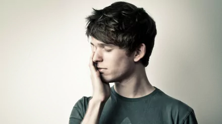 Man in contemplative pose against a neutral background, HD desktop wallpaper.