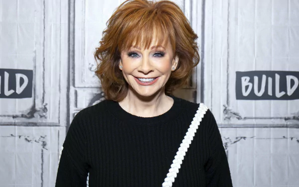Smiling woman with red hair posing in front of a backdrop with text, providing an elegant HD desktop wallpaper and background.