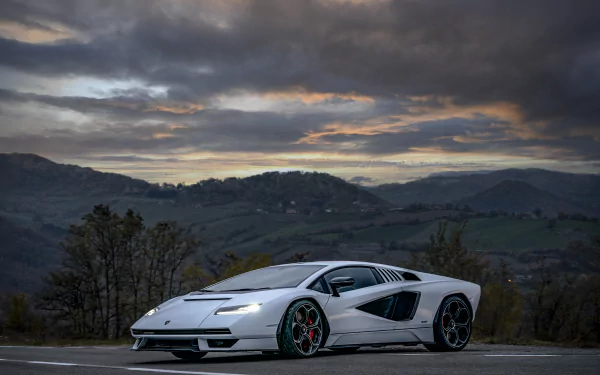 5K Ultra HD PC desktop wallpaper: white Lamborghini Countach LPI 800-4 supercar parked on a mountain road beneath dramatic sunset skies.