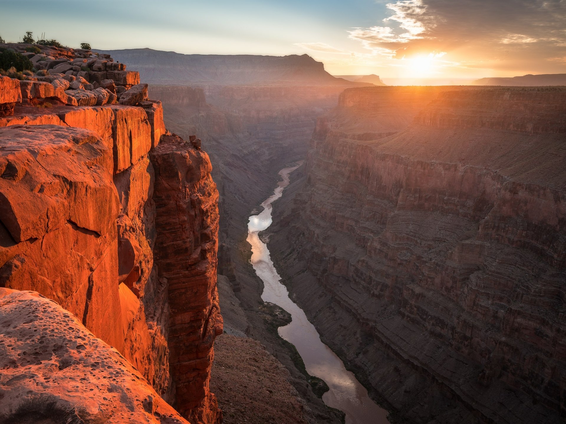2K Quad HD PC desktop wallpaper and background of a sunlit canyon: red rock cliffs overlooking a winding river through deep shadowed gorges at sunset.