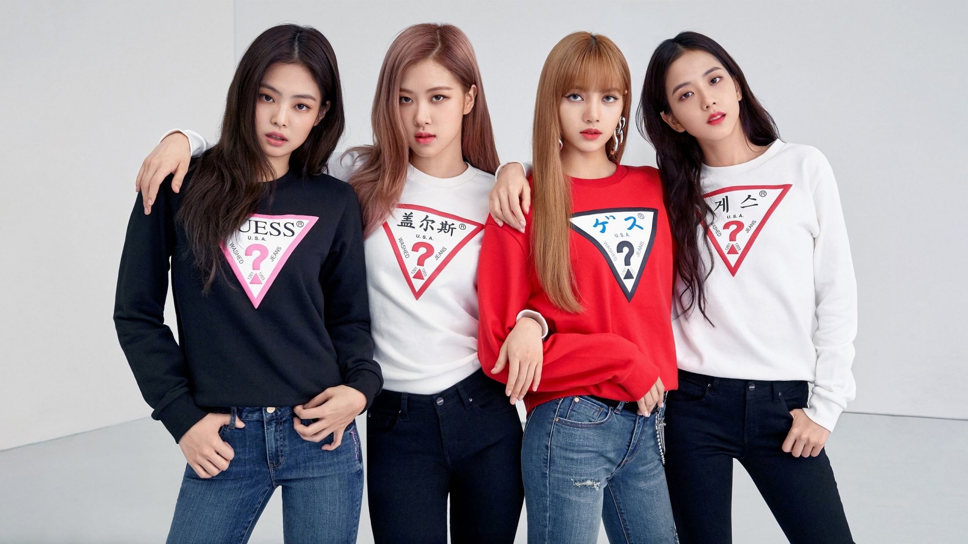 HD PC desktop wallpaper featuring the members of BlackPink posing together, showcasing their stylish sweaters with bold graphic designs.