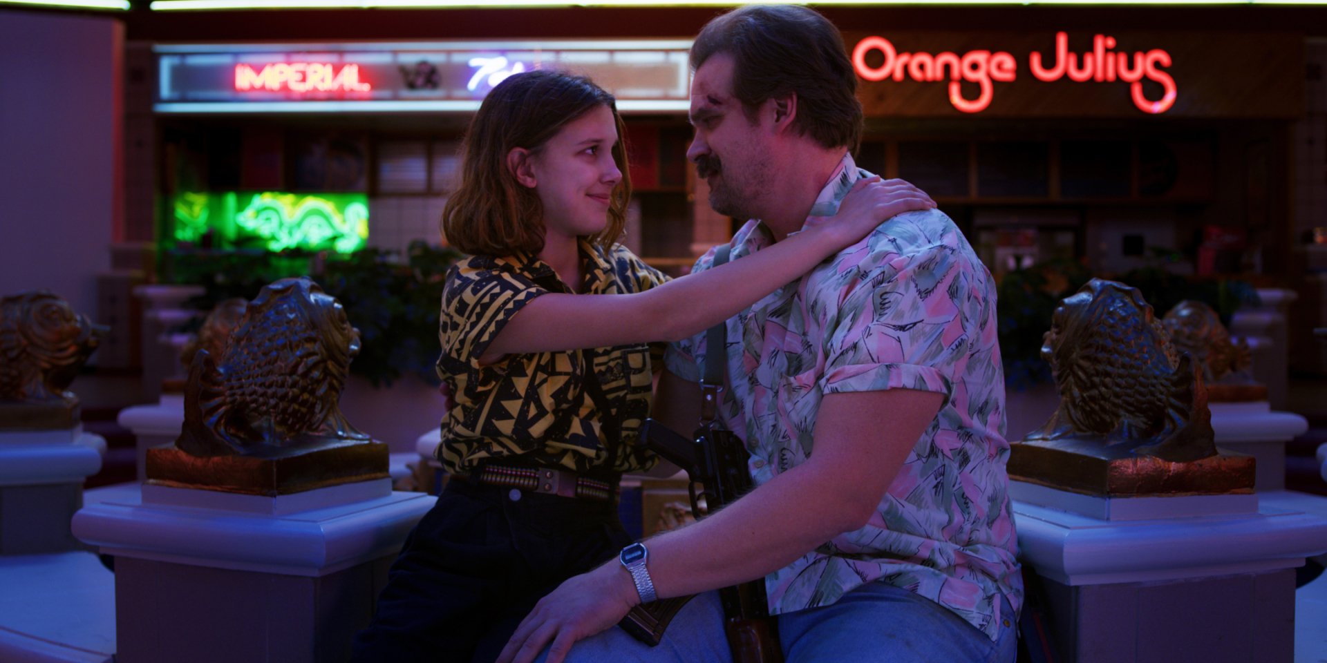 HD PC desktop wallpaper featuring a scene from the TV show Stranger Things with two characters sharing a moment outside a neon-lit Orange Julius.