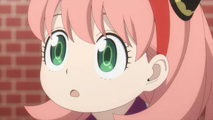HD PC desktop wallpaper: close-up anime portrait of Anya Forger from Spy x Family, pink hair and wide green eyes against a brick background.