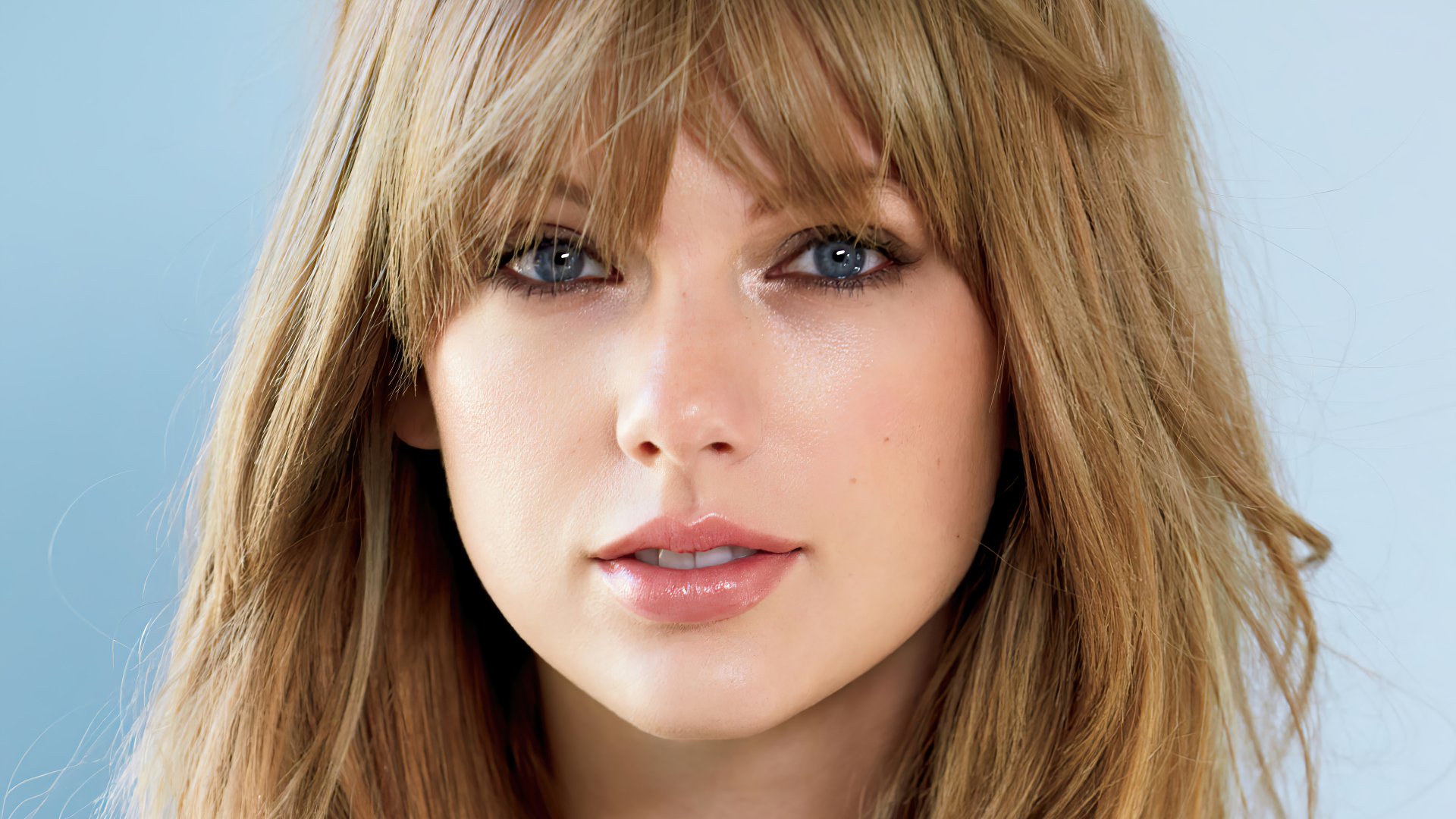 Close-up portrait of American singer Taylor Swift with blue eyes and blonde hair in 4K Ultra HD quality, captured as a desktop wallpaper background.