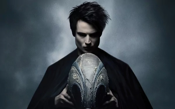 Cloaked figure from the TV show The Sandman holds an ornate helmet against a misty blue-gray backdrop — 4K Ultra HD PC desktop wallpaper/background.