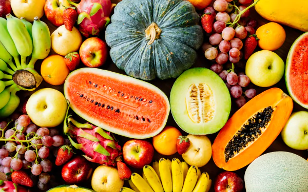 Colorful array of fresh fruit — halved watermelon, melon, papaya, bananas, grapes, apples — presented as a 5K Ultra HD PC desktop wallpaper background (food, fruit).