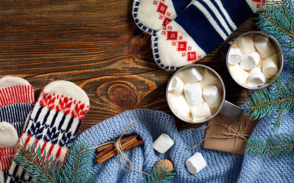 Steaming hot chocolate mug surrounded by festive cookies on a cozy winter-themed HD desktop wallpaper.