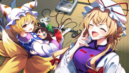 A vibrant 4K Ultra HD anime wallpaper featuring Yukari Yakumo, Ran Yakumo, and Chen from Touhou, with playful expressions and a classic game console in the background.
