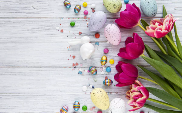 Colorful Easter eggs and tulips arranged on a white wooden surface, captured in vibrant 4K Ultra HD for a festive Easter holiday wallpaper.