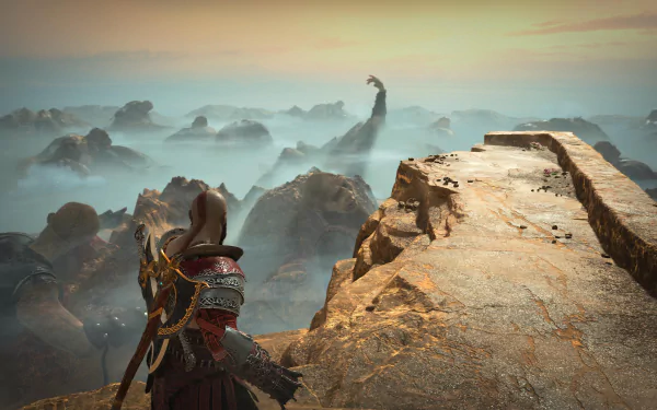 4K Ultra HD PC desktop wallpaper/background: Kratos (God of War) stands on a cliff edge, gazing across a fog-blanketed rocky landscape toward a distant towering giant.