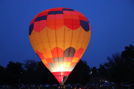 Glowing hot air balloon at dusk over trees at the Berea Spoonbread Festival in Kentucky — 5K Ultra HD photography for PC desktop wallpaper/background.
