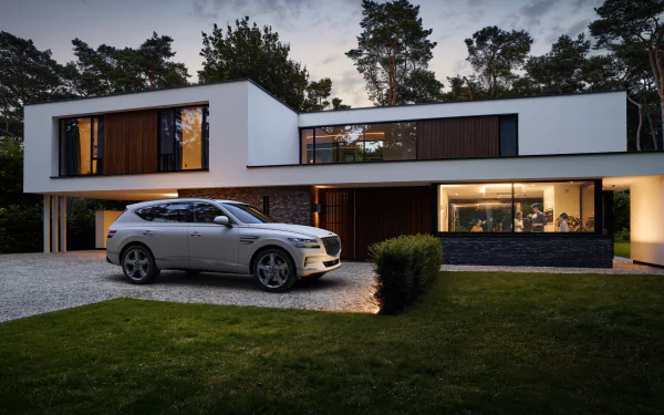 A Genesis GV80 parked in front of a modern house at dusk, captured in stunning 4K Ultra HD as a PC desktop wallpaper and background.