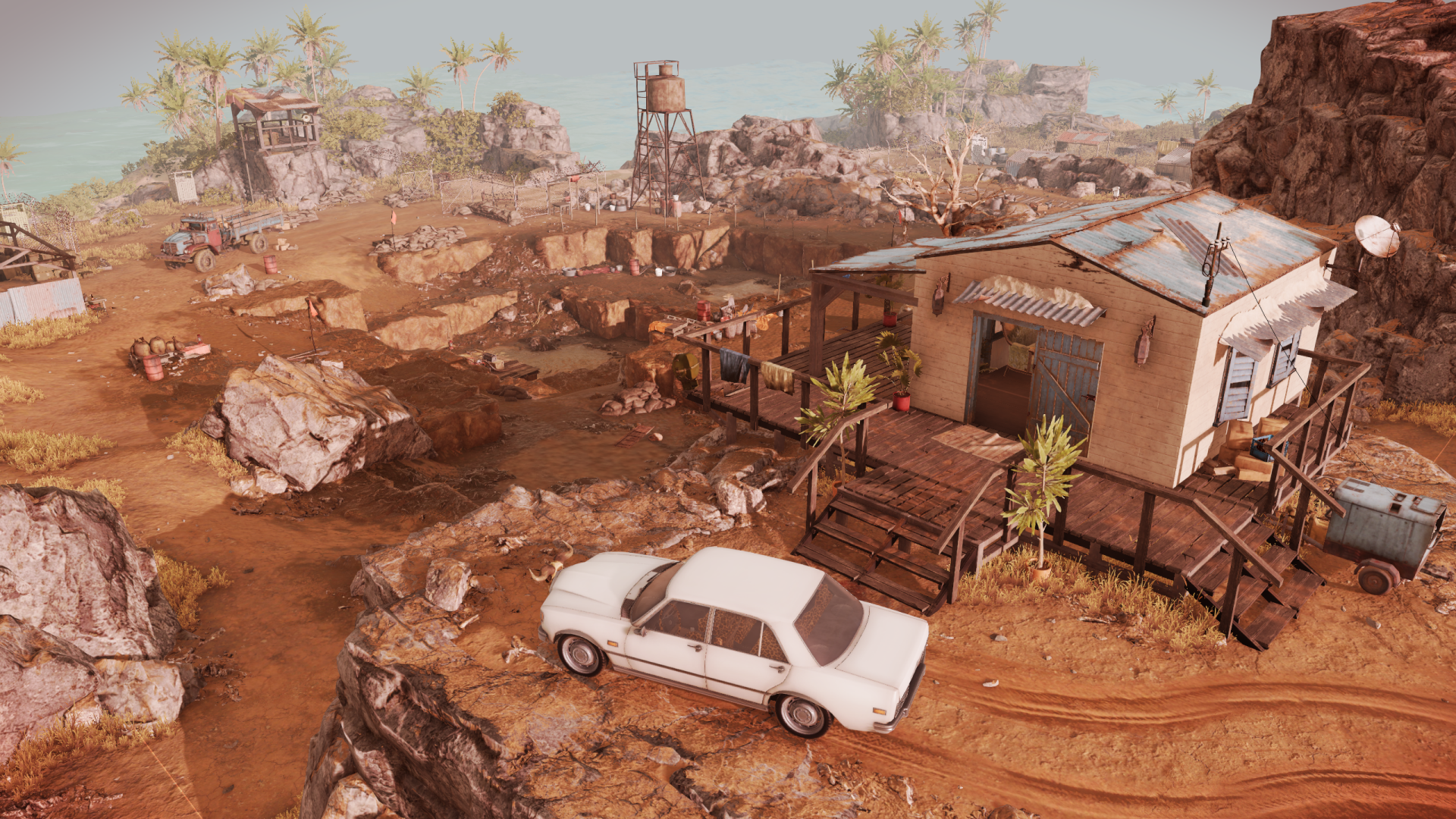 HD desktop wallpaper from the video game Jagged Alliance 3, depicting a detailed, arid game environment with a small outpost, vehicles, and scattered structures.