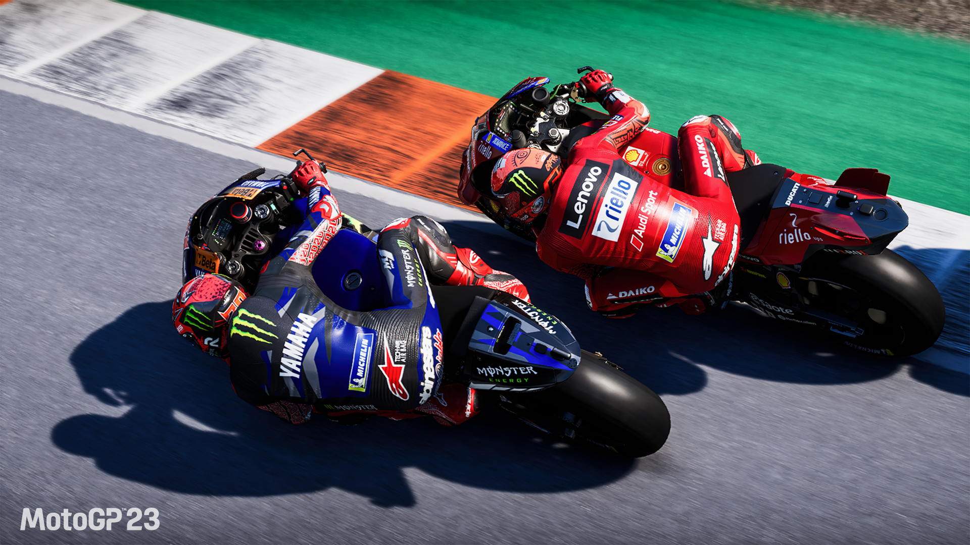 HD desktop wallpaper from the video game MotoGP 23 featuring two vibrant racing motorcycles in close competition on a race track.