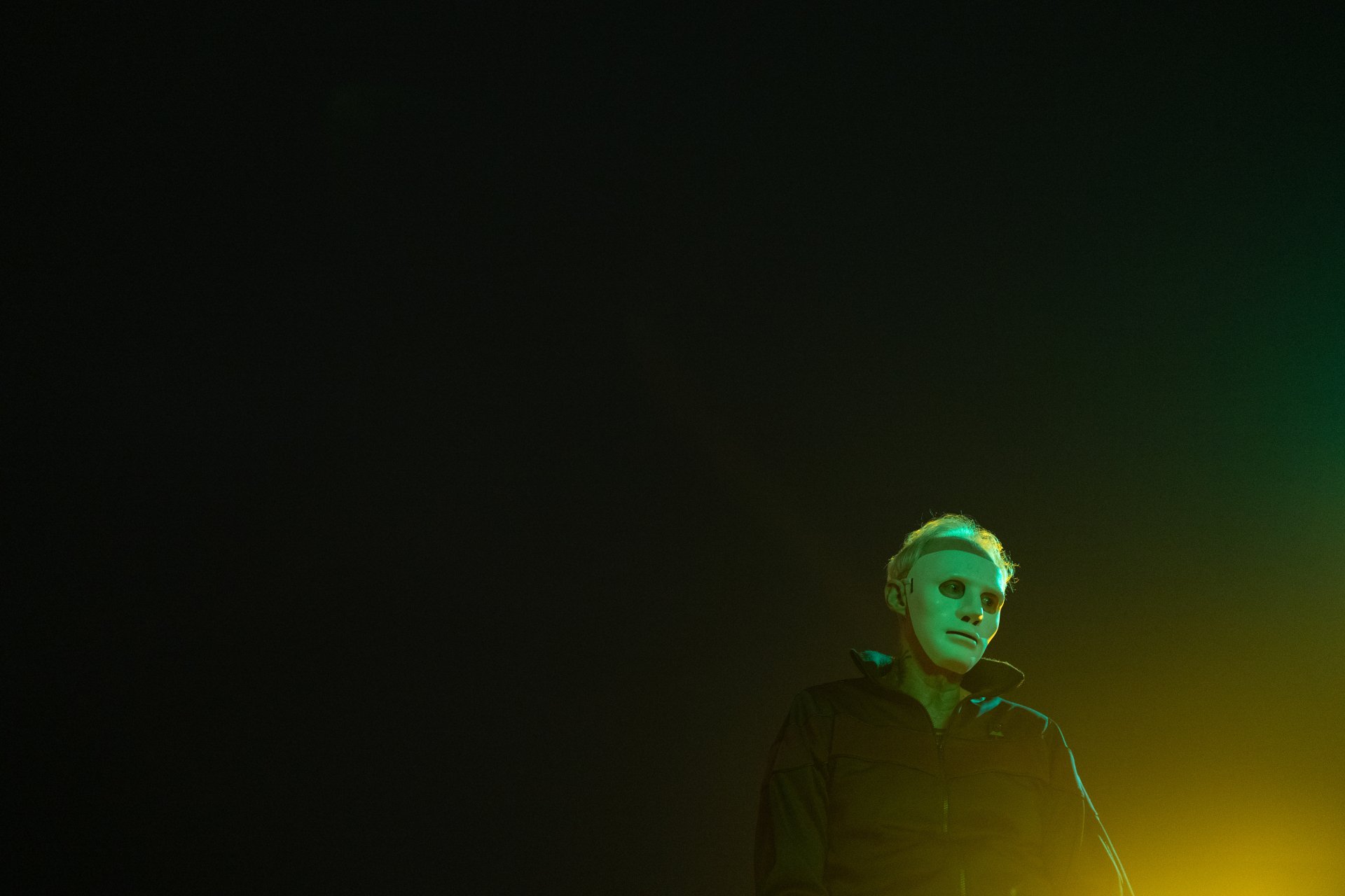 HD desktop wallpaper featuring a shadowy figure in a dark room with ominous green lighting, evoking a sense of mystery and suspense.